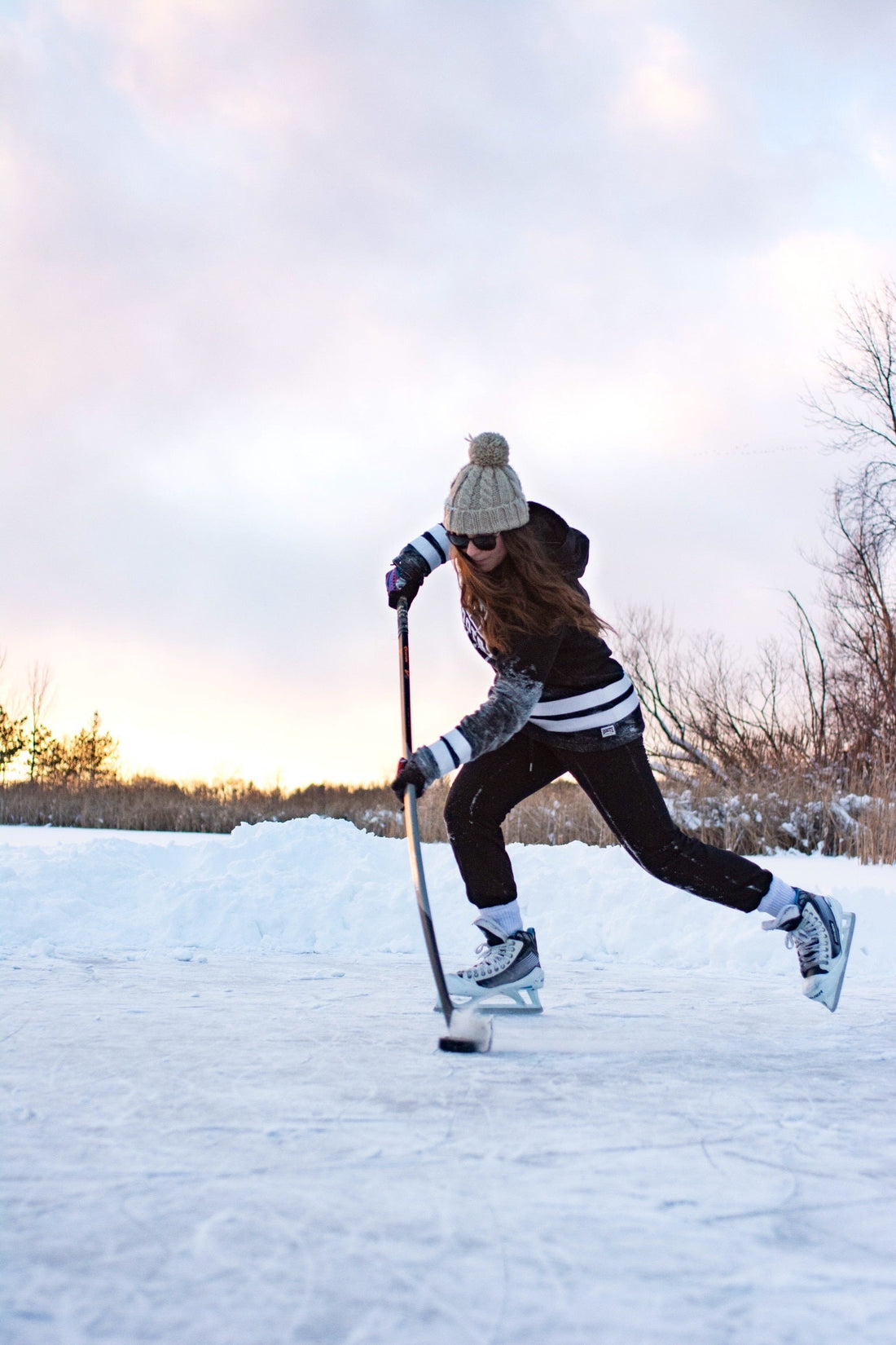 hockey player practicing stick handling on a frozen lake